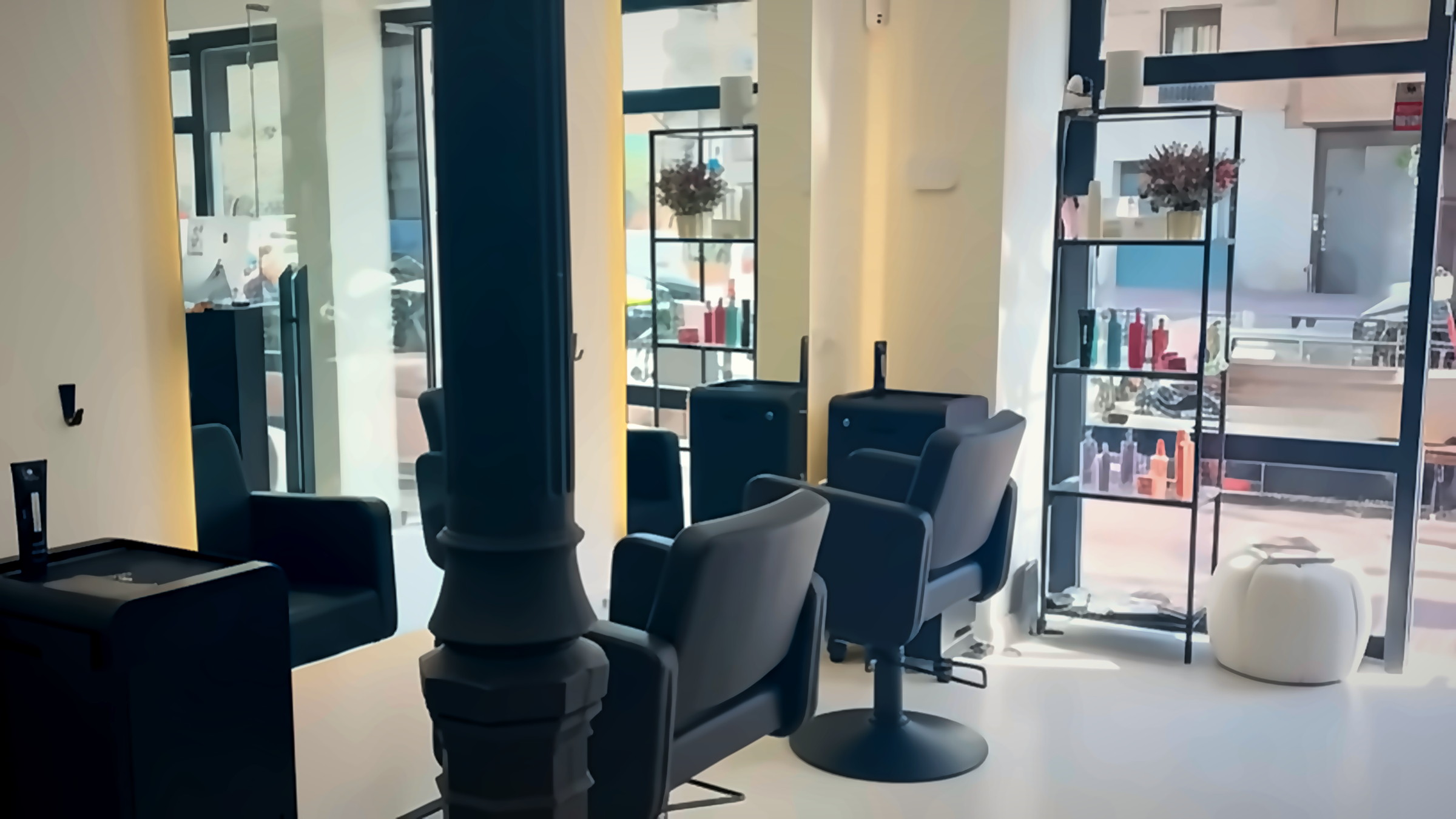 Interior boutique del salón Belyra Estilistas en Chamberí, Madrid: sillas de cuero, columna modernista y luz natural